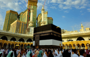 Pilgrims performing Tawaf around the Kaaba during Hajj 2025 in Makkah with modern high-rise buildings in the background
